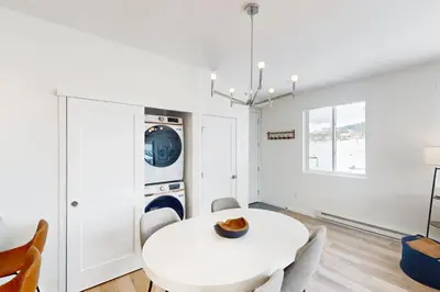 a white dining room with a white table and chairs at Sunnyside Up in Fraser