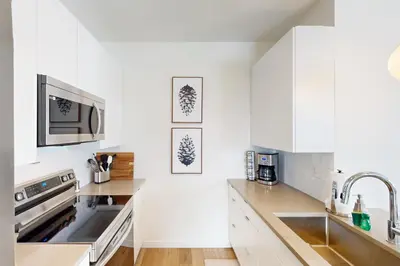a white kitchen with a sink and a microwave at Sunnyside Up in Fraser