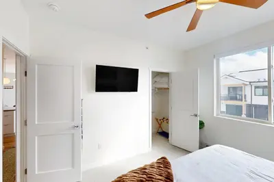 a bedroom with a ceiling fan and a tv on the wall at Sunnyside Up in Fraser