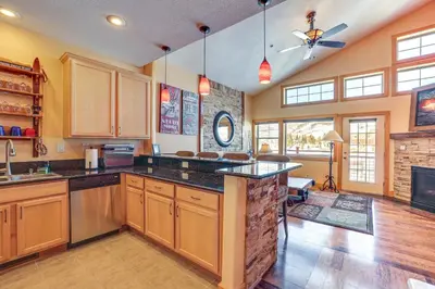 a large kitchen with wooden cabinets and a large island at 4 Mi to Ski Dillon Condo with Balcony and Mtn Views in Dillon