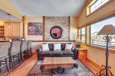 a living room with a leather couch and a table at 4 Mi to Ski Dillon Condo with Balcony and Mtn Views in Dillon