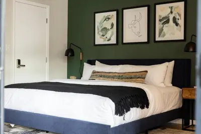 a bedroom with a large bed with green walls at Urban Gallery Loft - King Bed - Larimer Square in Denver