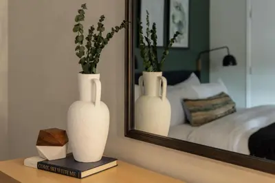 two white vases sitting on a table in front of a mirror at Urban Gallery Loft - King Bed - Larimer Square in Denver