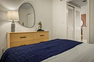 a bedroom with a bed with a mirror and a dresser at Urban Gallery Loft - King Bed - Larimer Square in Denver