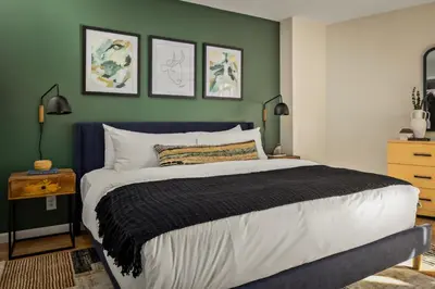 a bedroom with a large bed and a green wall at Urban Gallery Loft - King Bed - Larimer Square in Denver