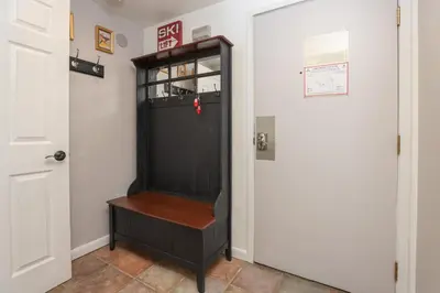 a black cabinet with a wooden seat next to a door at Wild Irishman Off-Piste Condo: Great Keystone Getaway in Keystone