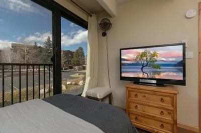 a bedroom with a television on a dresser with a window at Lodge at Lake Dillon Condo: Great Year-Round Location in Dillon