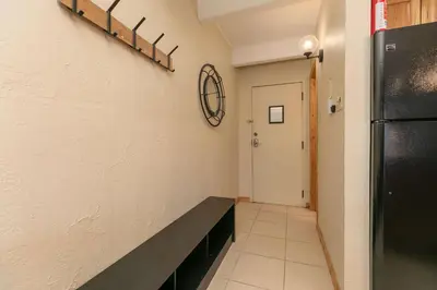 a hallway with a black bench and a refrigerator at Lodge at Lake Dillon Condo: Great Year-Round Location in Dillon