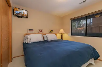 a bedroom with a large blue bed with a window at Frisco Mountainside Retreat: Walk Downtown in Frisco