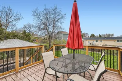 a patio table with a red umbrella on a deck at Centrally located for adventures in Westminster