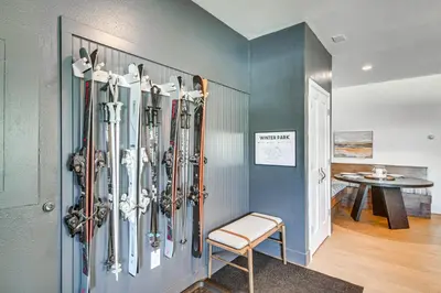 a room with a bunch of skis on a wall at Downtown Winter Park Condo with Free Bus to Ski Base in Winter Park
