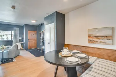 a living room with a table and a couch at Downtown Winter Park Condo with Free Bus to Ski Base in Winter Park