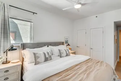 a bedroom with a large bed with a ceiling fan at Downtown Winter Park Condo with Free Bus to Ski Base in Winter Park