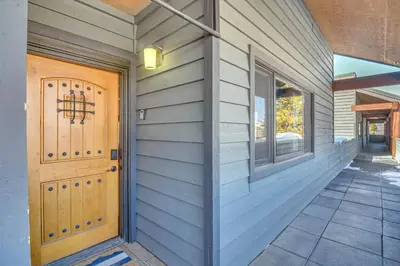 a house with a wooden door and a porch at Downtown Winter Park Condo with Free Bus to Ski Base in Winter Park