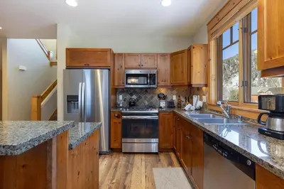 a kitchen with wooden cabinets and stainless steel appliances at 6533 Settlers Creek townhouse in Keystone