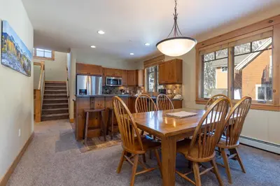 a kitchen and dining room with a wooden table and chairs at 6533 Settlers Creek townhouse in Keystone