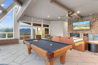 a pool table in a living room with a fireplace at Casa de Cristal-Epic Views-HotTub-Sauna-Sleeps 10-Luxury Linens-Stocked Kitchen in Estes Park
