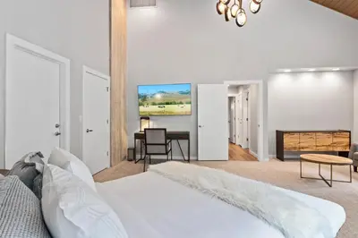 a white bedroom with a bed and a fireplace at Casa de Cristal-Epic Views-HotTub-Sauna-Sleeps 10-Luxury Linens-Stocked Kitchen in Estes Park