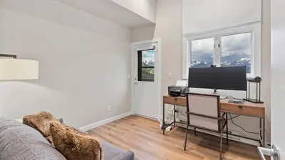 a living room with a desk with a television and a couch at Casa de Cristal-Epic Views-HotTub-Sauna-Sleeps 10-Luxury Linens-Stocked Kitchen in Estes Park