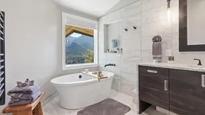 a bathroom with a white tub and a window at Casa de Cristal-Epic Views-HotTub-Sauna-Sleeps 10-Luxury Linens-Stocked Kitchen in Estes Park