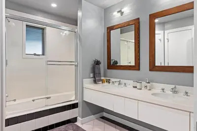 a white bathroom with two sinks and a shower at Casa de Cristal-Epic Views-HotTub-Sauna-Sleeps 10-Luxury Linens-Stocked Kitchen in Estes Park