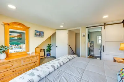 a bedroom with a large bed and a wooden dresser at Cozy Estes Park Condo with Balcony and Fireplace! in Estes Park