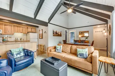 a living room with a couch and chairs and a kitchen at Cozy Estes Park Condo with Balcony and Fireplace! in Estes Park
