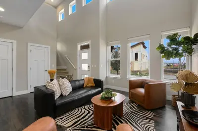 a living room with a black couch and a table at Exquisite Home by Old Town - Steps from Poudre Trail in Fort Collins