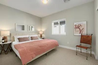 a bedroom with a large bed and a chair at Exquisite Home by Old Town - Steps from Poudre Trail in Fort Collins