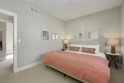 a bedroom with a large bed with a orange blanket at Exquisite Home by Old Town - Steps from Poudre Trail in Fort Collins