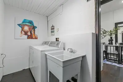 a bathroom with a washing machine and a sink at Old Town Retreat with Hot Tub - Steps from CSU! in Fort Collins