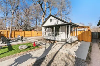 a small house in a yard with a fence at Old Town Retreat with Hot Tub - Steps from CSU! in Fort Collins