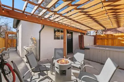 a patio with chairs and a table and a wooden pergola at Old Town Retreat with Hot Tub - Steps from CSU! in Fort Collins