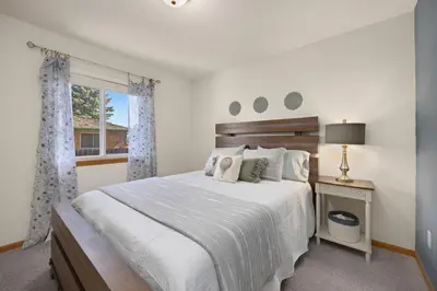 a bedroom with a white bed and a window at Charming Home with RV Parking - 30 miles from RMNP! in Loveland