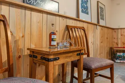 a bottle of wine on a table with a chair at Close to Trails, Parks & Open Space! Amazing Yard! in Fort Collins