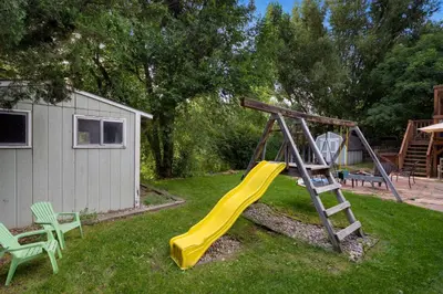 a playground with a yellow slide and a ladder at Close to Trails, Parks & Open Space! Amazing Yard! in Fort Collins