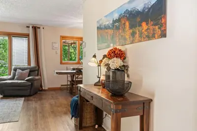 a living room with a table with a vase of flowers on it at Close to Trails, Parks & Open Space! Amazing Yard! in Fort Collins