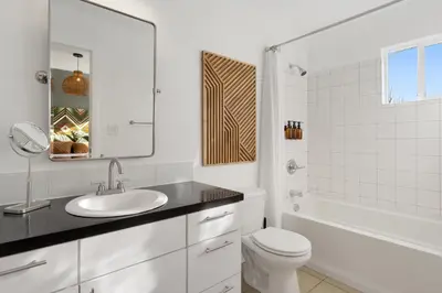 a white bathroom with a sink and a toilet at Coopers North in Old Town - Hot Tub & Pool Table! in Fort Collins