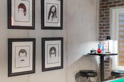 a wall with framed drawings of people on it at Coopers North in Old Town - Hot Tub & Pool Table! in Fort Collins