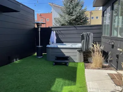 a backyard with green grass and a bath tub at Coopers North in Old Town - Hot Tub & Pool Table! in Fort Collins