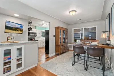 a kitchen with a counter and a bar with stools at Historic Mountain Ave Bungalow - Walk Everywhere! in Fort Collins