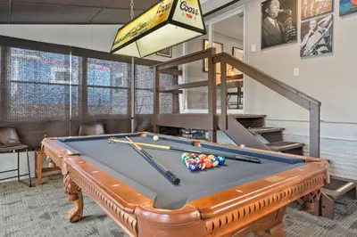 a pool table in the middle of a room at Historic Mountain Ave Bungalow - Walk Everywhere! in Fort Collins