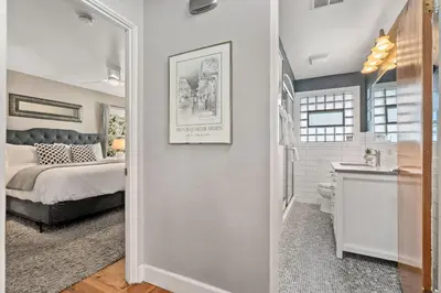 a bedroom with a bed and a bathroom with a sink at Historic Mountain Ave Bungalow - Walk Everywhere! in Fort Collins