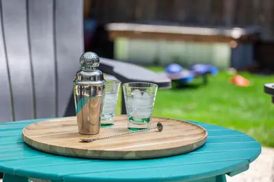 a wooden tray with two glasses and a shaker on a table at Historic Mountain Ave Bungalow - Walk Everywhere! in Fort Collins
