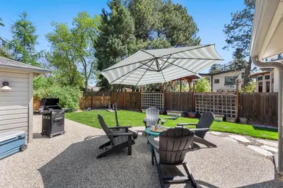 a patio with a table and chairs and an umbrella at Historic Mountain Ave Bungalow - Walk Everywhere! in Fort Collins