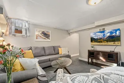 a living room with a couch and a tv at Garden Level Apt Mtn Ave - 8 min walk to Old Town! in Fort Collins