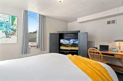 a bedroom with a bed and a desk and a television at Garden Level Apt Mtn Ave - 8 min walk to Old Town! in Fort Collins