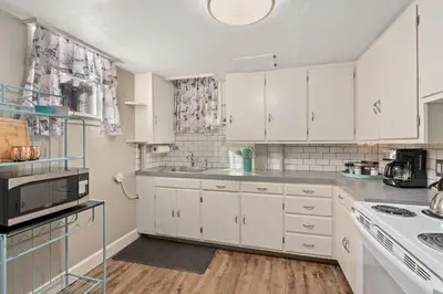 a white kitchen with white cabinets and a sink at Garden Level Apt Mtn Ave - 8 min walk to Old Town! in Fort Collins