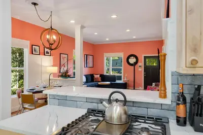 a kitchen with orange walls and a stove at The Magnolia House in Old Town - Private Hot Tub in Fort Collins