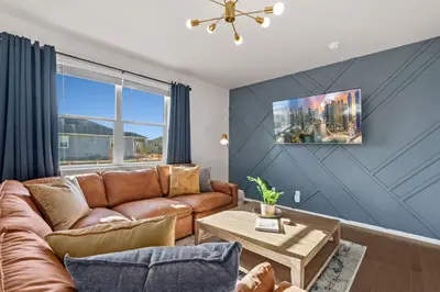 a living room with a couch and a table at NEW! Family-friendly Home with Pool Table, King Beds in Windsor